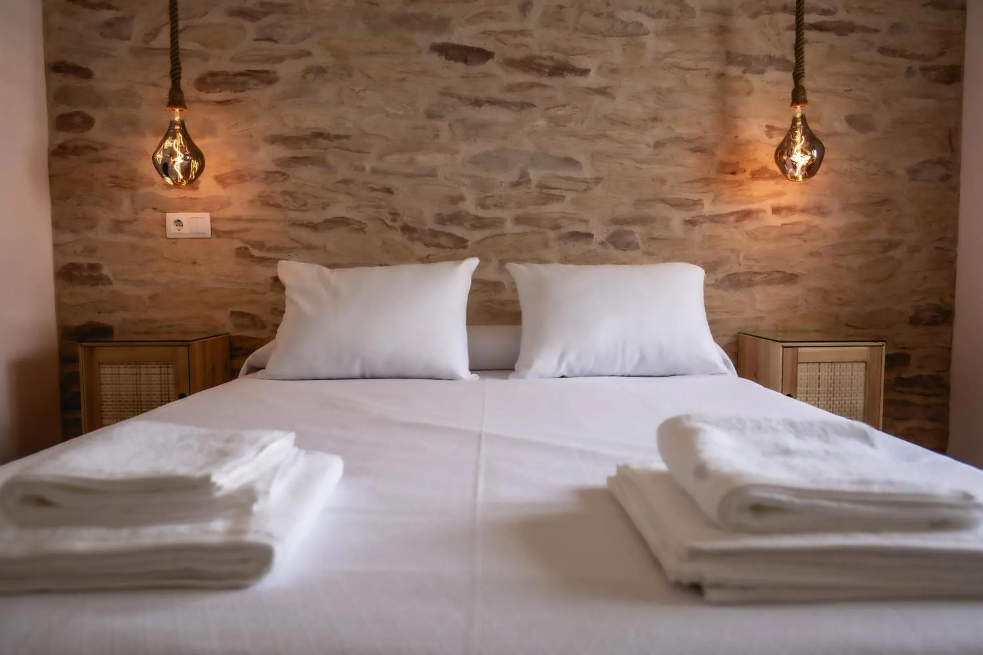 Dormitorio con pared de piedra vista